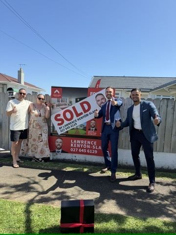 Sold sign with happy sellers