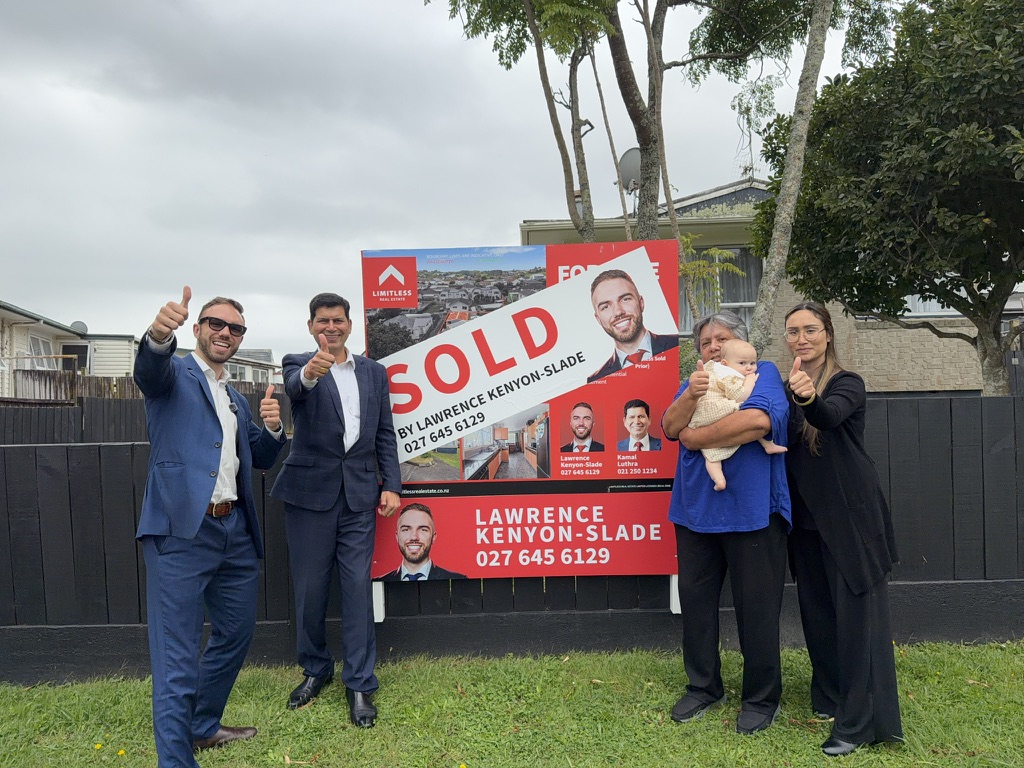 Sold sign with happy sellers and family